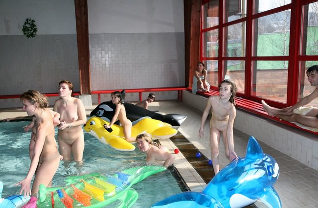 Nudists relax naked in a hotel with a swimming pool